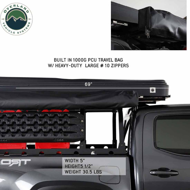 Image of a roof-mounted awning in closed position showing black built-in travel bag with heavy-duty zippers installed on a pickup truck rack, side profile view on white background.