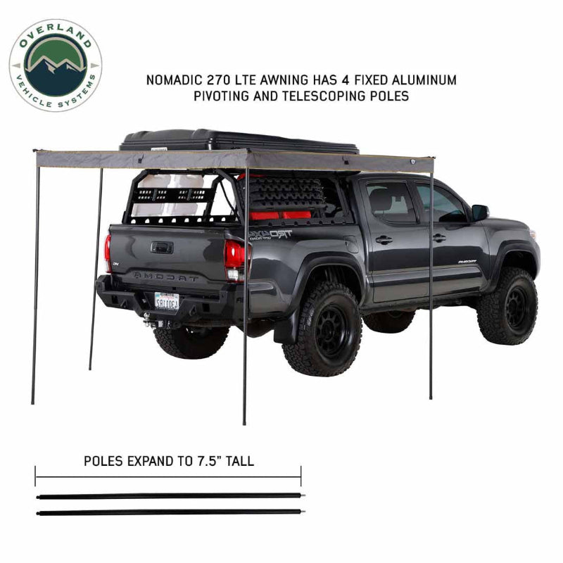 Image of a pickup truck with a roof-mounted 270-degree awning deployed using four telescoping support poles, gray fabric canopy extending along side and rear, angled rear and side view on white background.