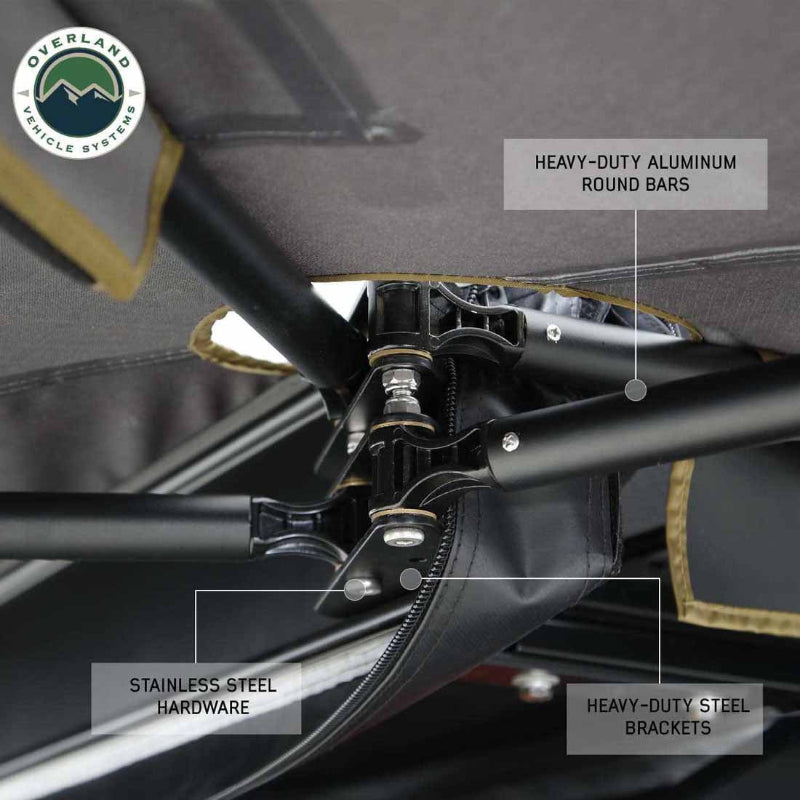 Image of a roof-mounted awning hardware close-up showing heavy-duty aluminum support bars, stainless steel hardware, and reinforced steel brackets under gray fabric canopy.
