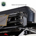Image of a roof-mounted awning pivot mechanism showing aluminum support arms, reinforced hinge point, and stainless steel hardware inside the protective cover, close-up detail view on white background.