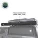 Image of an OVS HD Nomadic 2-person car-side shower and privacy room packed in a premium 840D travel cover and mounted on a roof rack, shown in side view on a white background.