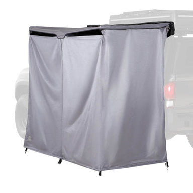 Image of an OVS HD Nomadic 2-person car-side shower and privacy room fully deployed on a vehicle, grey fabric panels forming an enclosed space, shown in angled side view on a white background.