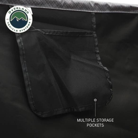 Image of a close-up of an OVS HD Nomadic 2-person car-side shower and privacy room interior showing integrated black mesh storage pockets for organizing personal items, displayed on a white background.