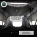 Image of the interior of an Overland Vehicle Systems Nomadic Standard rooftop tent, featuring a high-density foam mattress and an overhead storage loft for accessories, bedding, and clothing. A window is visible in the back, and the interior walls are grey