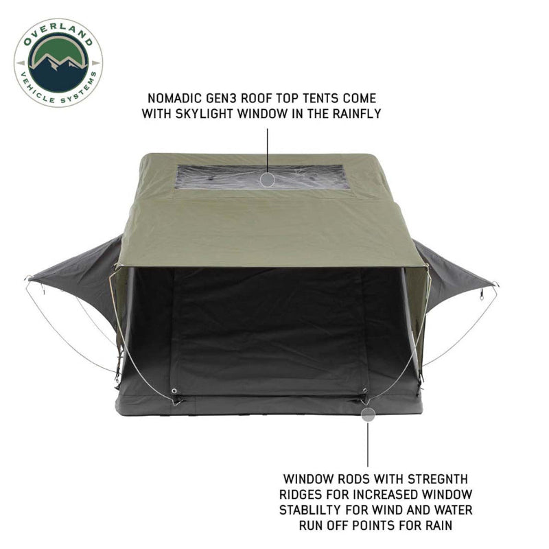 Image of an Overland Vehicle Systems Nomadic GEN3 rooftop tent, partially deployed with a green rainfly and a clear skylight window. The tent features a black fabric body and includes window rods with strength ridges for increased stability and rain runoff