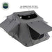 Image of a Nomadic 3 Extended roof top tent shown from a side and top-down angled view, with the built-in skylight with mesh and a side window awning open. The tent is dark grey and displayed on a white background