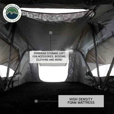 Image of the interior of an Overland Vehicle Systems rooftop tent, showing the overhead storage loft for accessories, bedding, and clothing, and a high-density foam mattress on the floor
