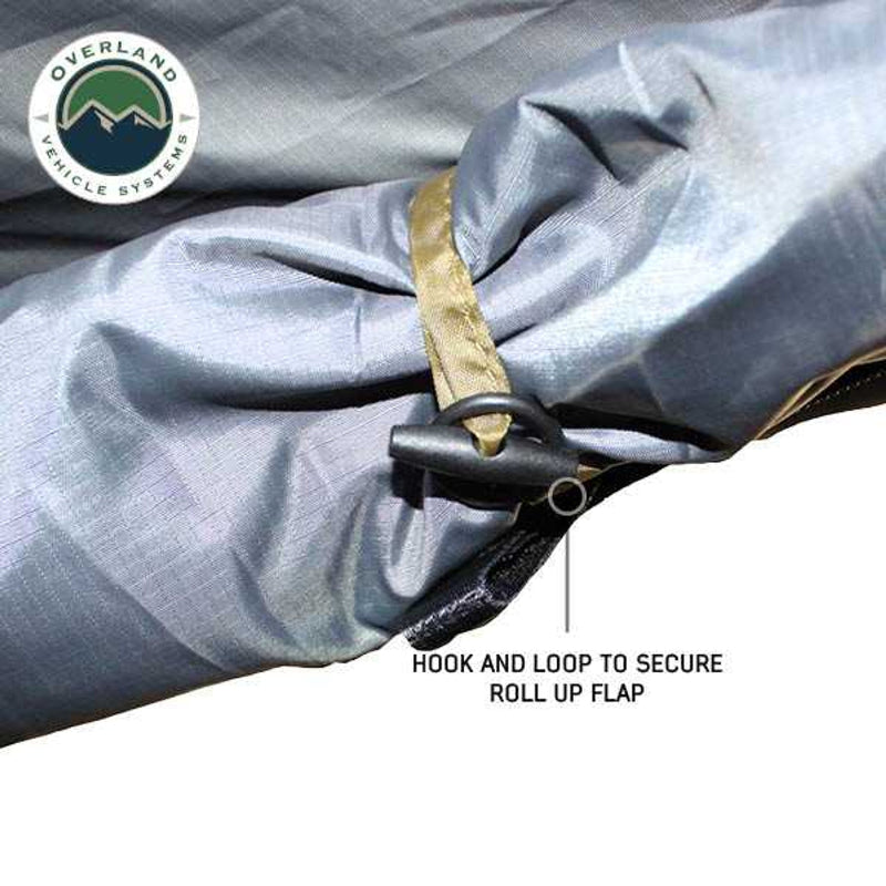 Image of a close-up of a grey awning room enclosure wall rolled up and secured with a hook-and-loop strap and buckle, showing fabric detail on a white background.