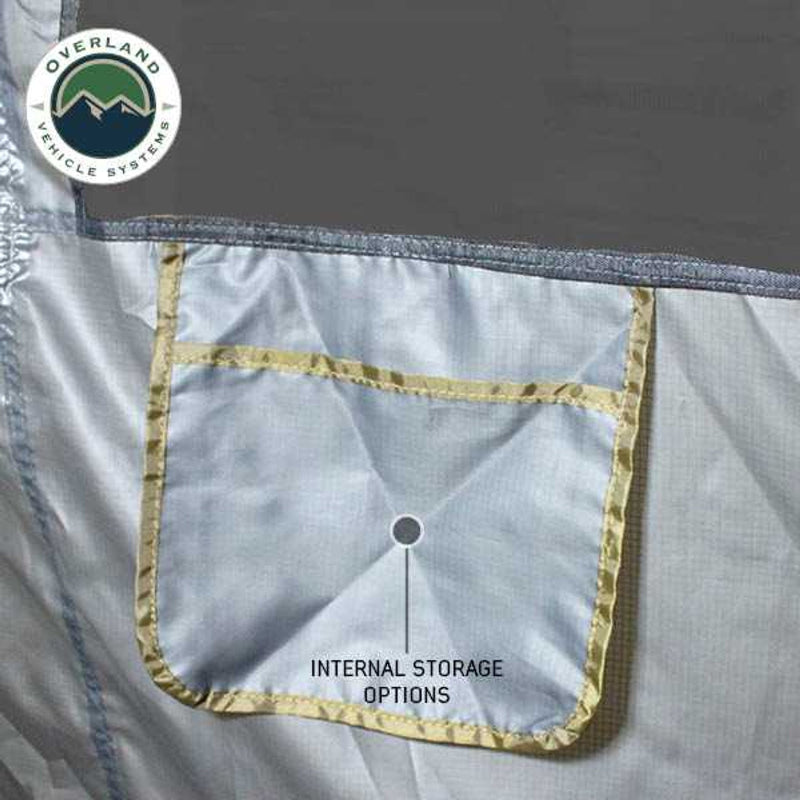 Image of a close-up of a grey awning room enclosure interior showing an integrated fabric storage pocket with reinforced stitching, displayed in detail on a white background.