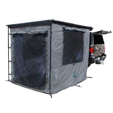 Image of a vehicle-mounted awning room enclosure fully deployed at the rear of a pickup truck, grey fabric with mesh window panels, rectangular tent-style design attached to an open tailgate, shown in angled rear and side view on a white background.