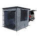 Image of a vehicle-mounted awning room enclosure fully deployed at the rear of a pickup truck, grey fabric with mesh window panels, rectangular tent-style design attached to an open tailgate, shown in angled rear and side view on a white background.