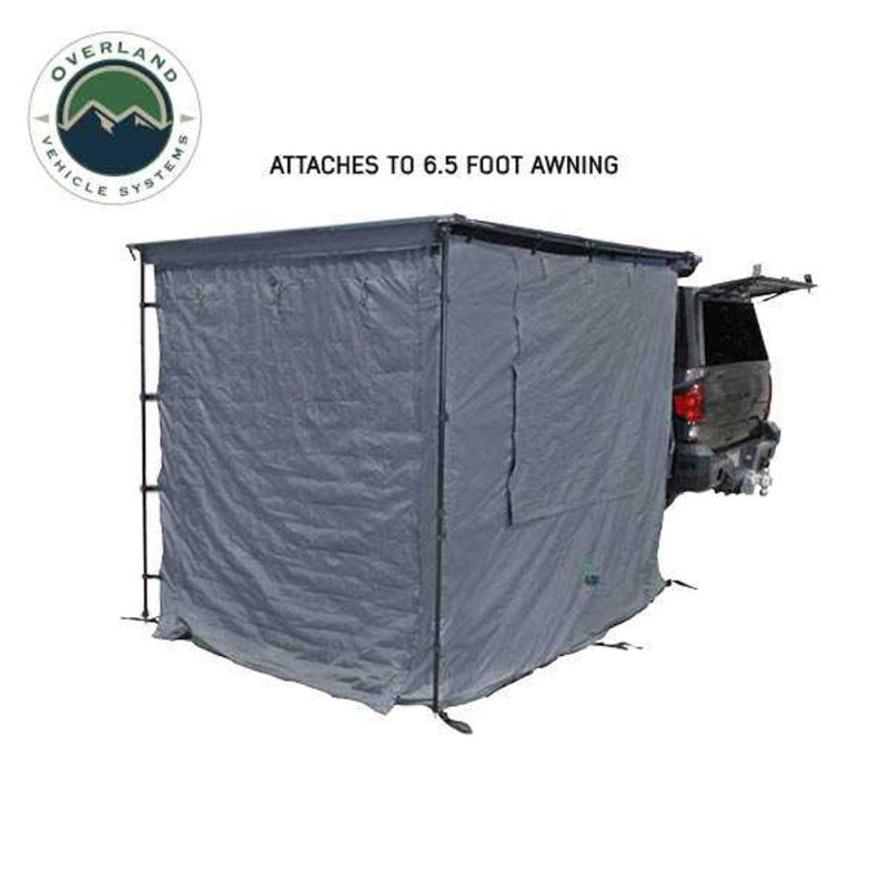 Image of a vehicle-mounted awning room enclosure attached to a 6.5-foot awning at the rear of a pickup truck, solid grey fabric walls fully enclosed, shown in angled rear and side view on a white background.