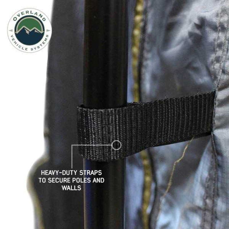 Image of a close-up of a vehicle awning room enclosure showing a heavy-duty black strap securing the fabric wall to a vertical support pole, highlighted in detail on a white background.