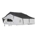 Image of a white Nomadic Extended rooftop tent with a dark grey roof cover, fully set up and extended, viewed from the front and side on a white background