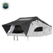 Image of a white Nomadic Extended rooftop tent with a dark grey roof cover and extended awning, fully set up, shown from a slightly elevated front angle on a white background