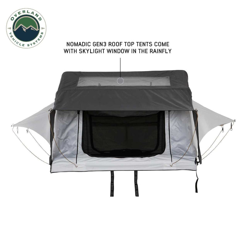 Image of a Nomadic Gen3 rooftop tent with its dark grey rainfly featuring a clear skylight window, shown from the front with the tent fully set up against a white background