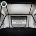 Image of the interior of a Nomadic rooftop tent, showcasing a 3-inch high-density memory foam mattress with a soft-touch quilted cover, along with the tent's white walls and black support poles