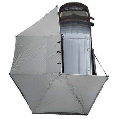 Image of the OVS Nomadic 270 Awning fully deployed from a vehicle, seen from a high angle to show the full 270-degree coverage of the light grey poly cotton ripstop canvas material