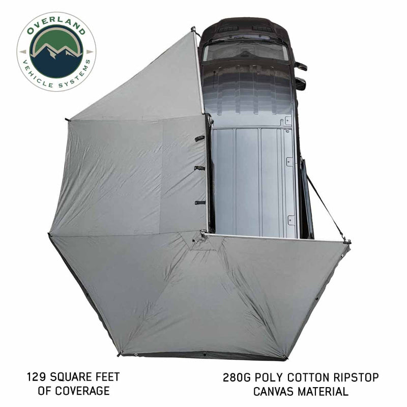 Image of the OVS Nomadic 270 Awning fully deployed from a vehicle, seen from a high angle to show the full 270-degree coverage of the light grey 280G poly cotton ripstop canvas material. The text indicates 129 square feet of coverage