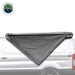 Image of the OVS Nomadic Awning partially deployed on the side of a white van, showing the dark grey fabric rolled out in a triangular shape