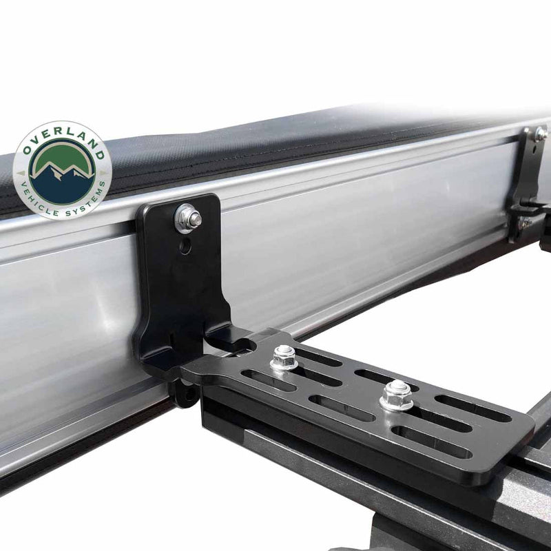 Image of the OVS Nomadic Awning showing a close-up of a single heavy-duty mounting bracket securing the awning to a vehicle's roof rack