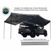 Image of the OVS Nomadic 270 Awning fully deployed on the side and rear of a grey truck, supported by telescoping aluminum poles. The awning is black on both sides