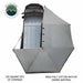 Image of the OVS Nomadic 270 Awning fully deployed from a vehicle, seen from a high angle to show the full 270-degree coverage of the light grey 280G poly cotton ripstop canvas material. The text indicates 129 square feet of coverage