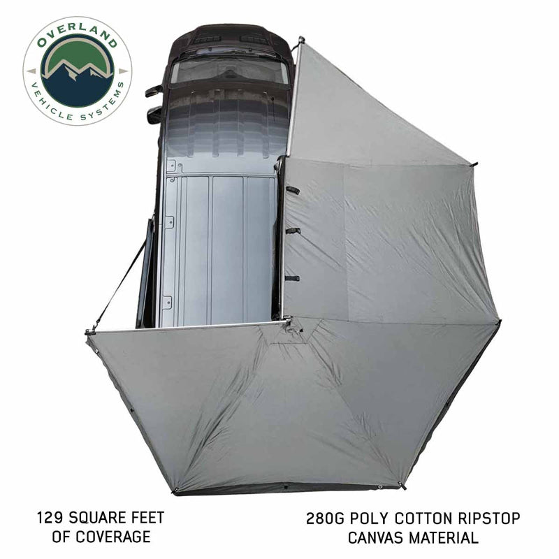 Image of the OVS Nomadic 270 Awning fully deployed from a vehicle, seen from a high angle to show the full 270-degree coverage of the light grey 280G poly cotton ripstop canvas material. The text indicates 129 square feet of coverage