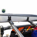 Image of the mounting brackets for the Overland Vehicle Systems Nomadic 180 Awning, showing how the awning attaches to a vehicle's roof rack. The aluminum frame of the awning and the black steel mounting hardware are visible