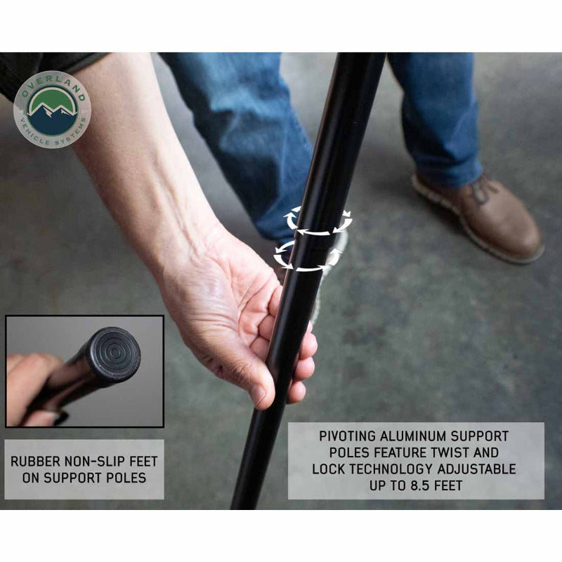 Image of a hand twisting the pivoting aluminum support pole of the OVS Nomadic 180 Awning to lock it in place. A smaller inset image shows a close-up of the rubber non-slip feet on the support poles