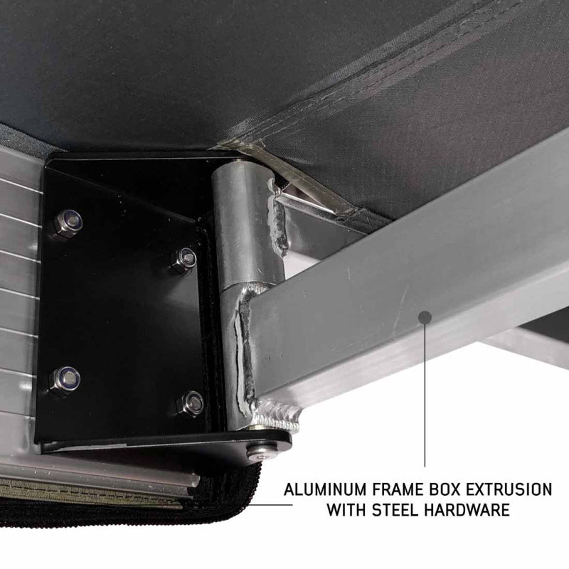 Image of the mounting point for the Overland Vehicle Systems Nomadic 180 Awning, highlighting the aluminum frame box extrusion with steel hardware. The underside of the awning fabric and the sturdy bracket are shown up close