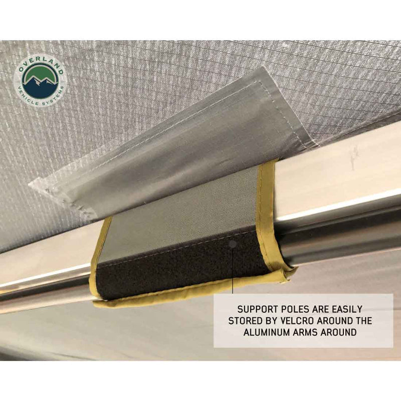 Image of a close-up on the Overland Vehicle Systems' Nomadic 180 Awning frame, showing the awning fabric and the support pole attached with a Velcro strap to the aluminum arm. Text on the image points out that all seams are heat-sealed for durability