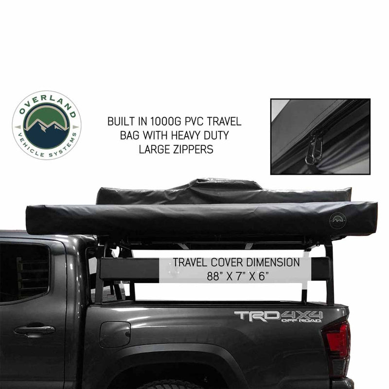 Image of the OVS Nomadic 180° Awning secured in its black travel cover on a vehicle rack, with an inset showing the zipper detail and the cover dimensions