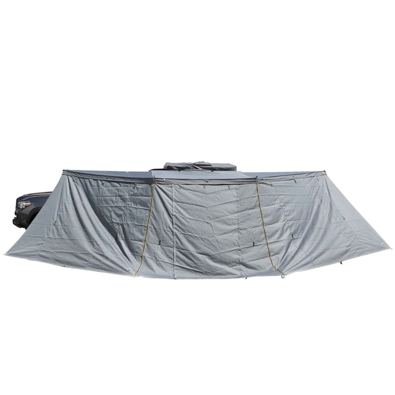 Image of the OVS Nomadic 180° Awning with the optional zip-in wall fully deployed, showing the entire length of the awning and wall from a front-facing perspective on a white background
