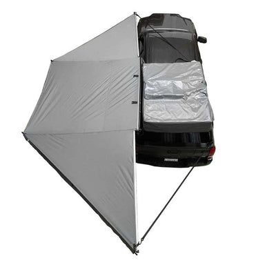 Image of the OVS Nomadic 180° Awning with the optional zip-in wall deployed, showing a top-down view of the gray fabric and the additional wall for a fully enclosed shelter