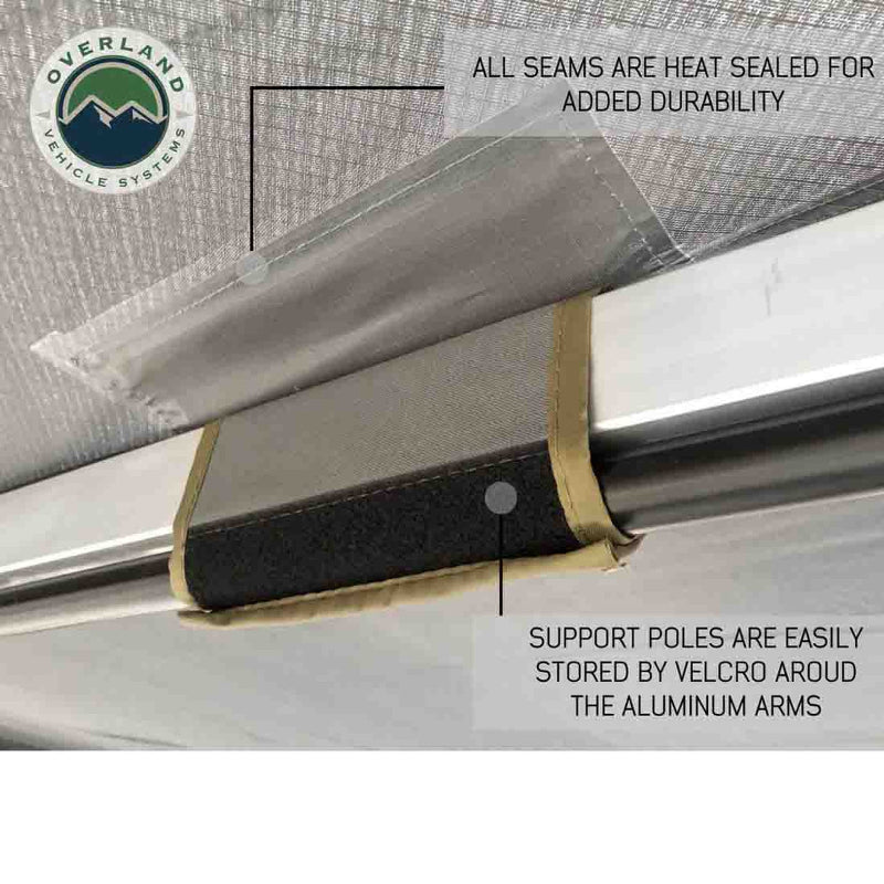 Image of the underside of the OVS Nomadic 180° Awning, highlighting the heat-sealed seams for durability and a support pole neatly stored with velcro straps around the aluminum arm