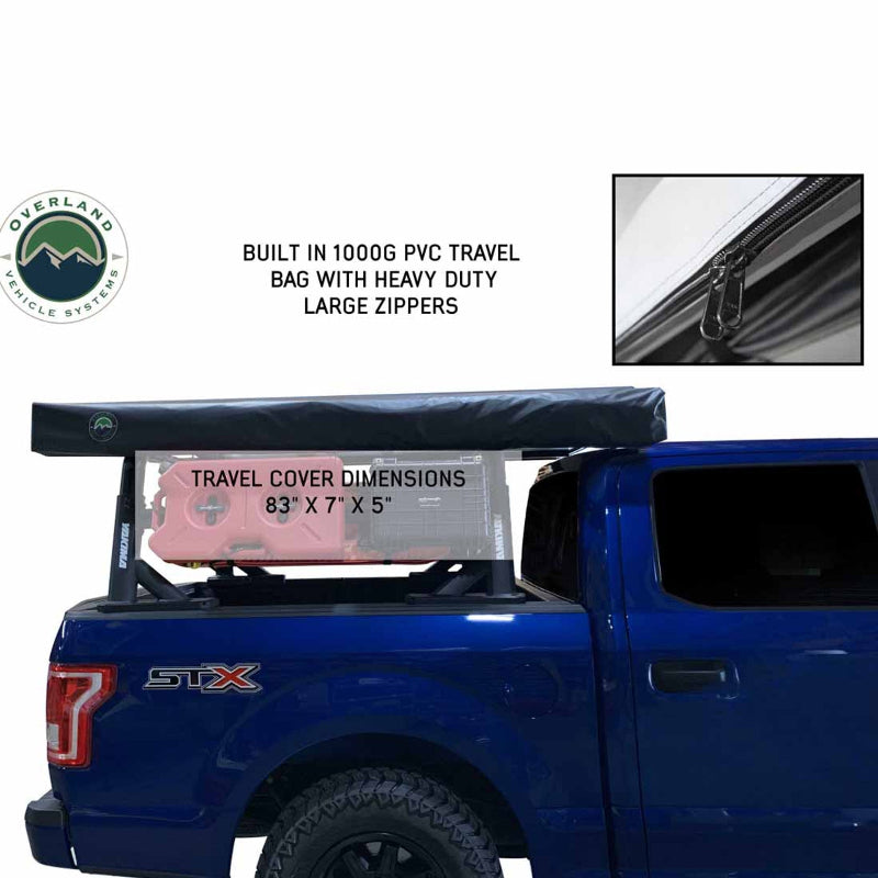 Image of a blue pickup truck with a black rooftop awning in its travel cover, mounted on a rack over the truck bed. An inset image shows a close-up of the heavy-duty zipper on the travel bag, with text noting "BUILT IN 1000G PVC TRAVEL BAG WITH HEAVY DUTY LARGE ZIPPERS" and "TRAVEL COVER DIMENSIONS 83" X 7" X 5""