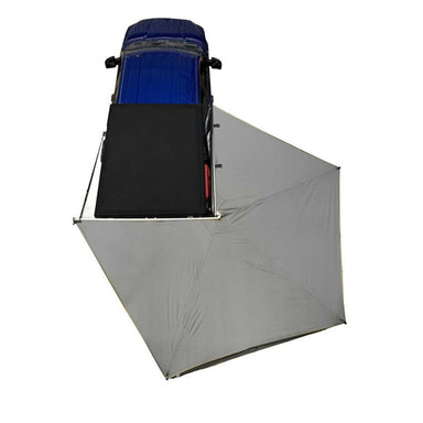 Image of a blue truck with a rooftop tent and a gray awning partially deployed. This top-down view shows the truck and awning on a white background