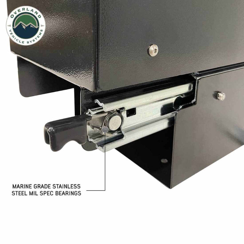 Image of Overland Vehicle Systems slide-out camping storage system bearing detail showing marine-grade stainless steel mil-spec slide bearings and black powder-coated steel housing, close-up angled view on a white background.