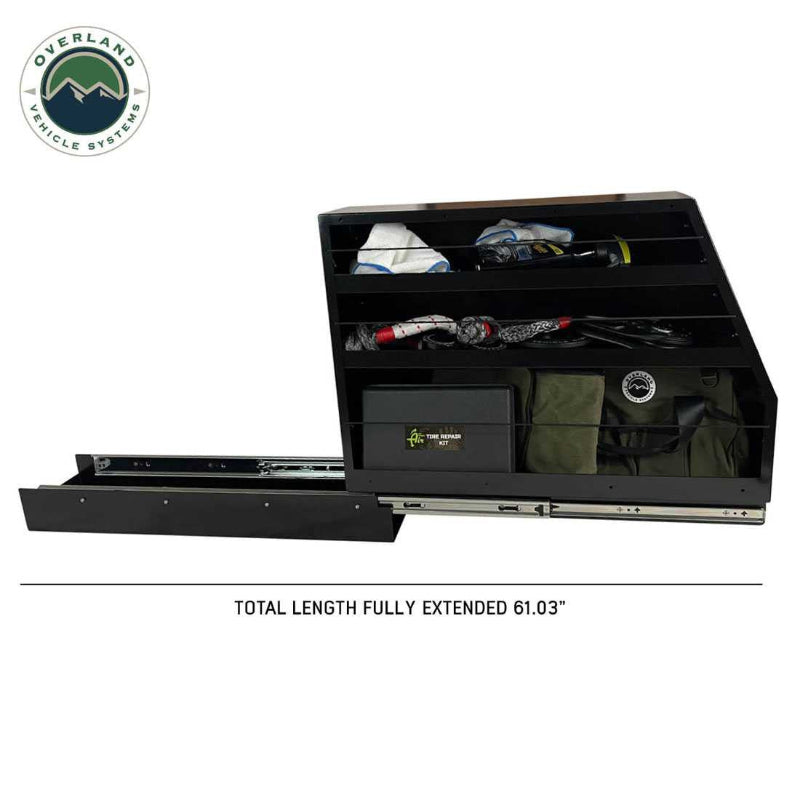 Image of Overland Vehicle Systems slide-out camping storage system fully extended with organized gear on multi-level shelves, black powder-coated steel construction, side view showing full extension on a white background.