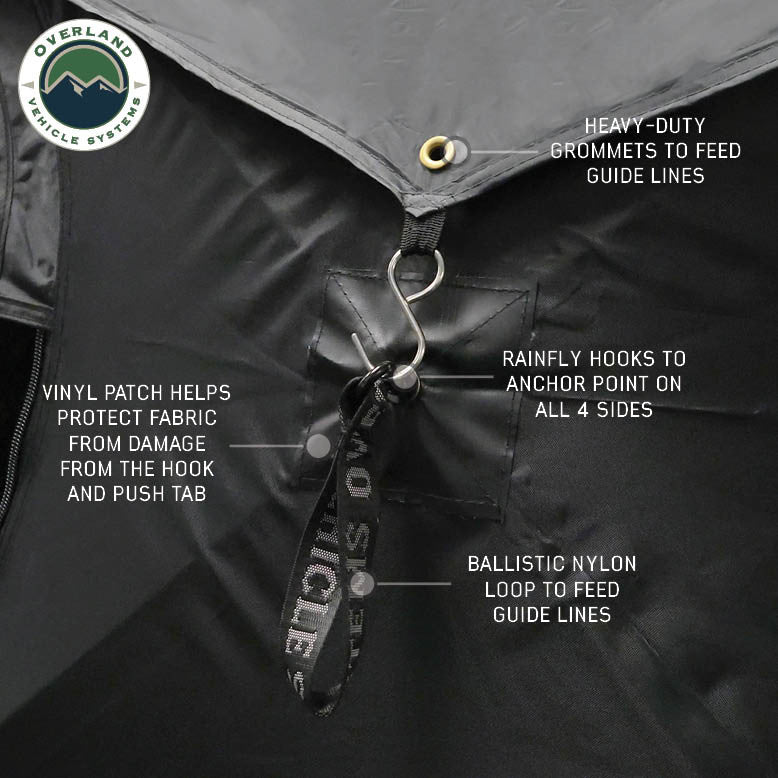 Image of OVS hub-style camping tent rainfly attachment detail showing heavy-duty grommets, hooks, and ballistic nylon loops, black fabric construction, close-up angled view on a neutral background.