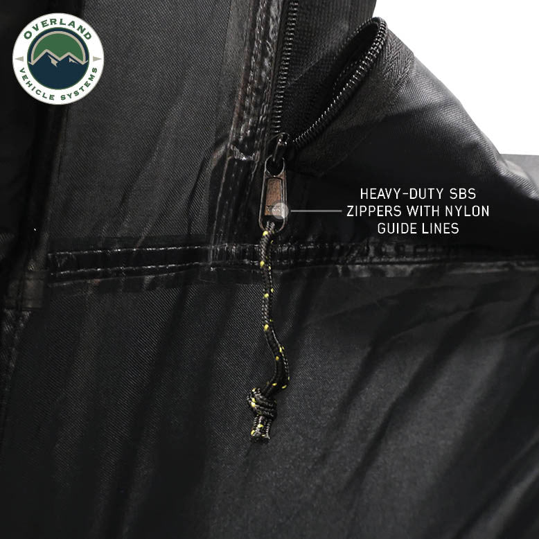 Image of OVS hub-style camping tent zipper detail showing heavy-duty SBS zipper with nylon guide lines, black fabric construction, close-up angled view on a neutral background.