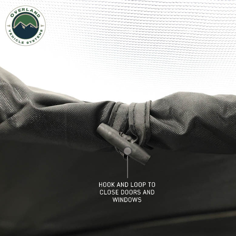 Image of OVS hub-style camping tent closure detail showing hook-and-loop fastener for securing doors and windows, black fabric with mesh backing, close-up angled view on a neutral background.