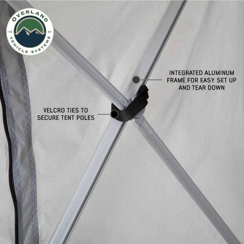A close-up of the OVS ground tent's frame, showing the integrated aluminum poles and Velcro ties for securing them. The detail highlights the easy setup and tear-down feature of the tent's structure