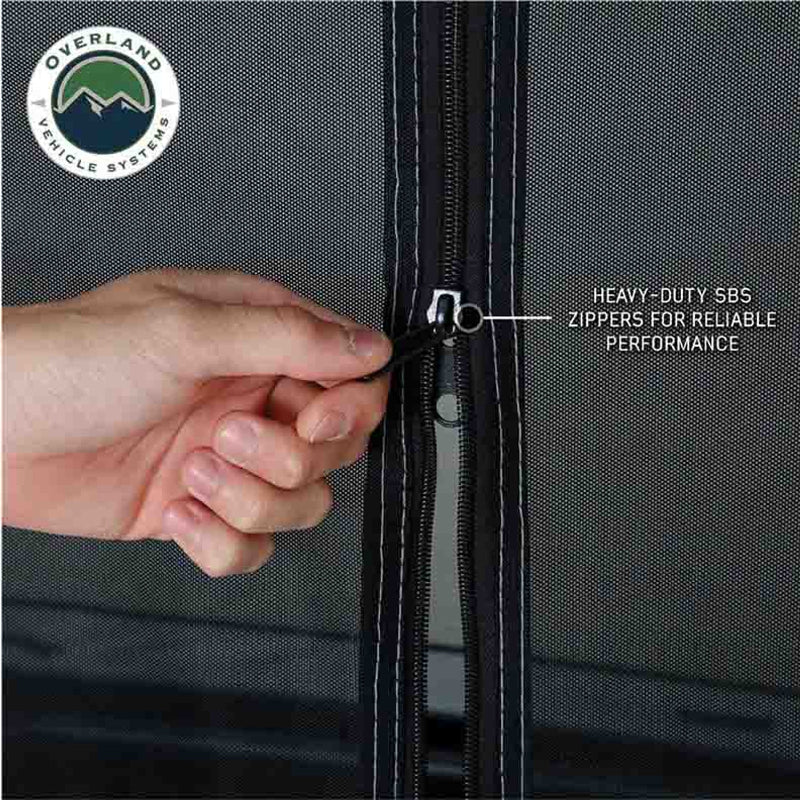 A close-up of a hand zipping up the tent's mesh door, demonstrating the heavy-duty SBS zippers. The image highlights the heavy-duty SBS zippers for reliable performance.