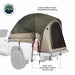 Image of a pickup truck bed tent installed on a white truck, olive green and tan 420D ripstop weatherproof fabric with rear mesh door and heavy-duty adjustable straps, angled side and rear view on white background.