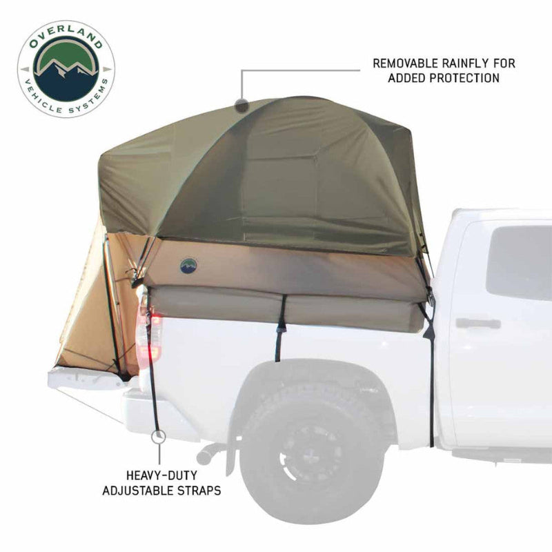 Image of a pickup truck bed tent installed on a white truck, olive green and tan fabric with removable rainfly and adjustable straps, side view showing rear overhang on white background.