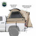 Image of a pickup truck bed tent installed on a white truck, tan and olive green fabric with large breathable mesh window and weatherproof panels, angled side view on white background.