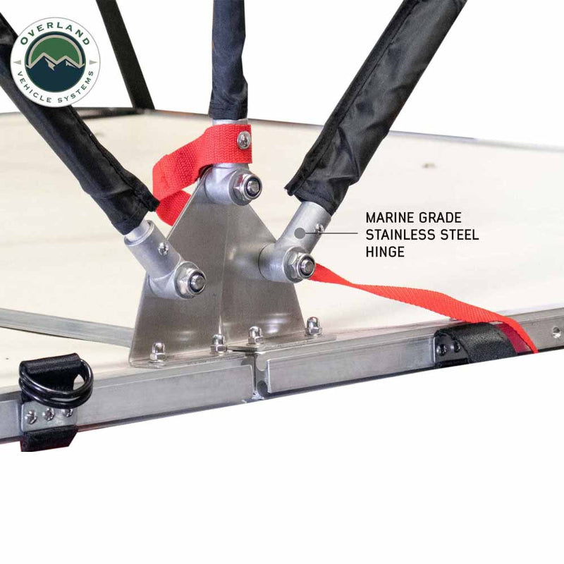 Image detailing a marine-grade stainless steel hinge on a tent's frame, showing its robust construction with multiple connection points and red straps.