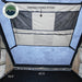 Image displaying a close-up of a heavy-duty nylon strap with grab handles, designed to simplify the closing of an Overland Vehicle Systems tent. The strap is black and shown against the beige tent fabric